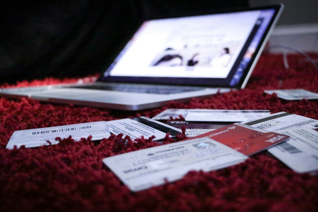 Credit cards and a laptop on a rug.