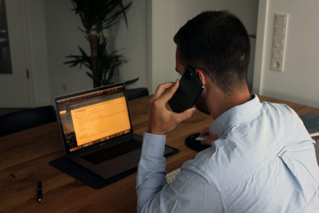 A person makes a phonecall while reading an email.