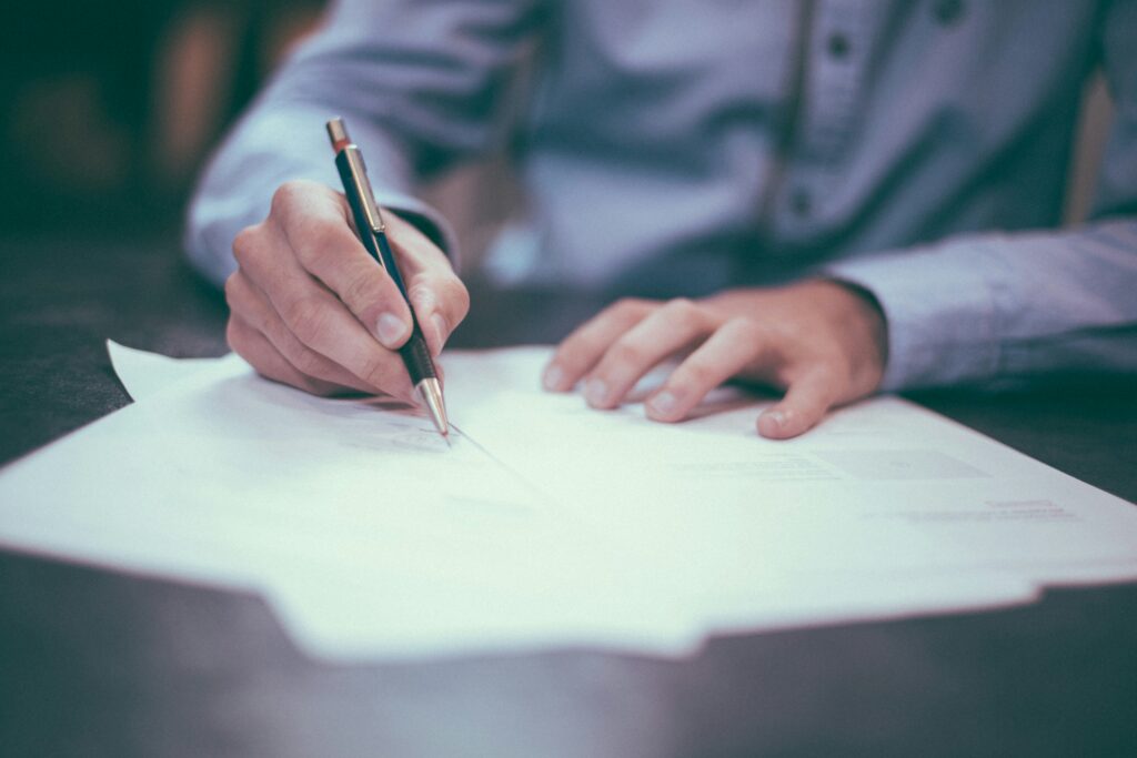 A person signs a document.
