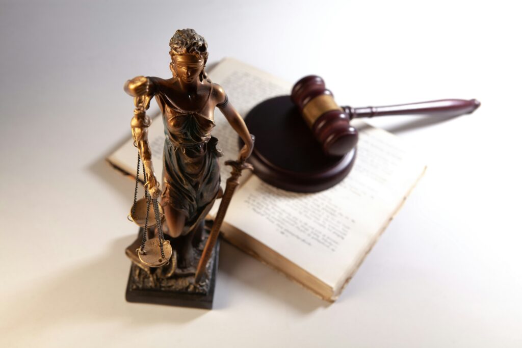 A justice statue, a gavel, and a book.
